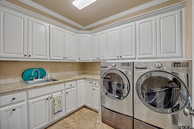 laundry area featuring ornamental molding, separate washer and dryer, cabinets, and sink