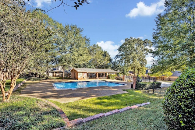 view of pool with a patio and a lawn