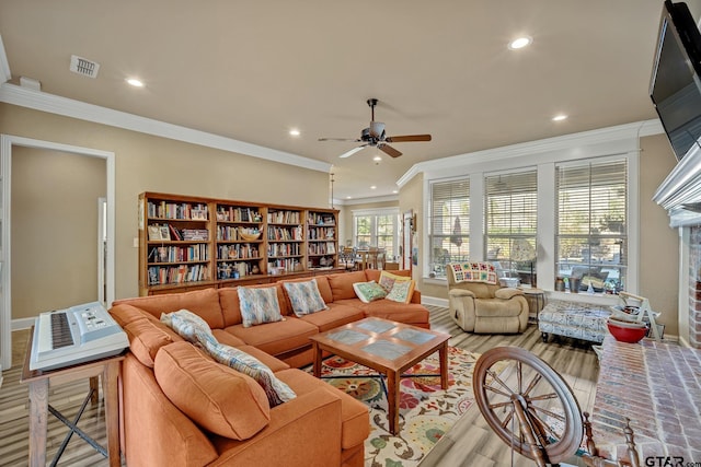 living room with light hardwood / wood-style flooring, ceiling fan, and crown molding