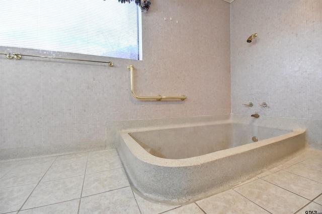 bathroom with tile patterned flooring and a tub