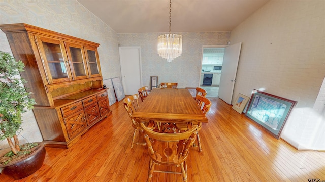 dining space with light hardwood / wood-style floors, beverage cooler, and an inviting chandelier