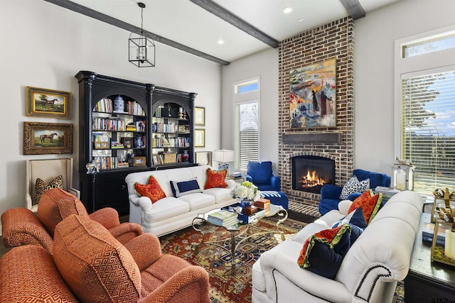 living room with a brick fireplace and beam ceiling