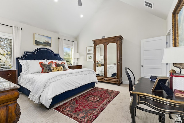 bedroom featuring ceiling fan, multiple windows, high vaulted ceiling, and light carpet