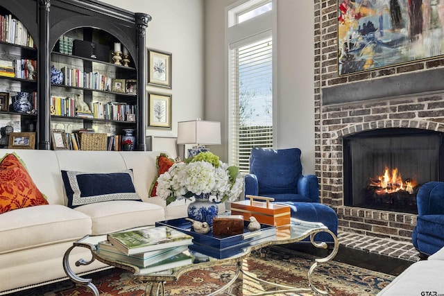 living room featuring a brick fireplace and built in shelves