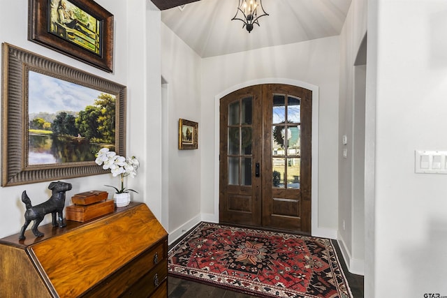 entrance foyer featuring french doors, vaulted ceiling, and dark hardwood / wood-style flooring