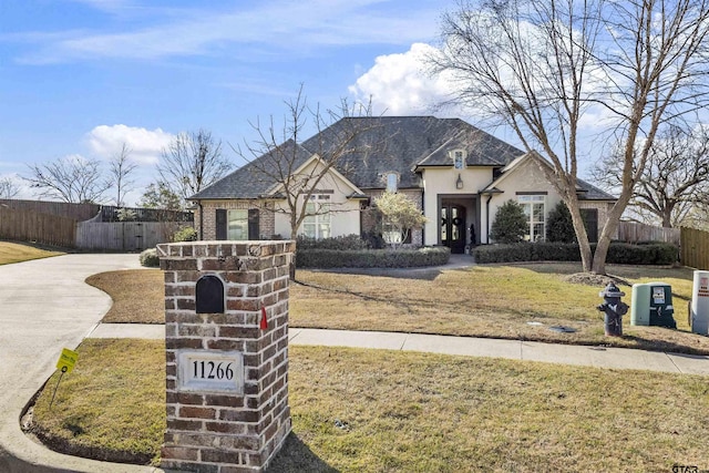 french country inspired facade with a front lawn