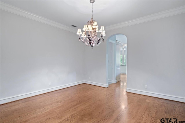 empty room with light hardwood / wood-style floors, a notable chandelier, and ornamental molding