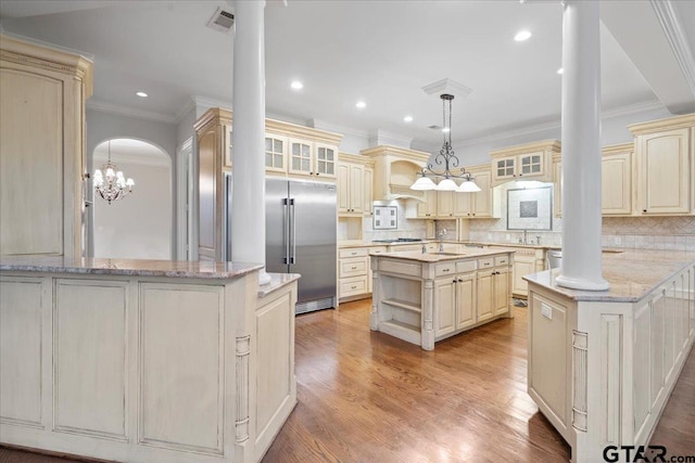 kitchen featuring a kitchen island, stainless steel built in refrigerator, and cream cabinetry