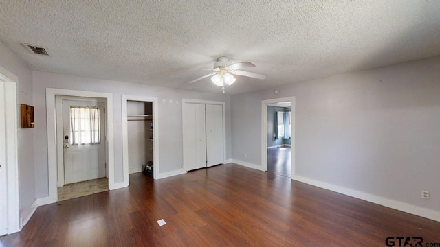 280 Dickard St, Hawkins, TX 75765 - unfurnished bedroom with dark wood-style floors, baseboards, visible vents, ceiling fan, and multiple closets
