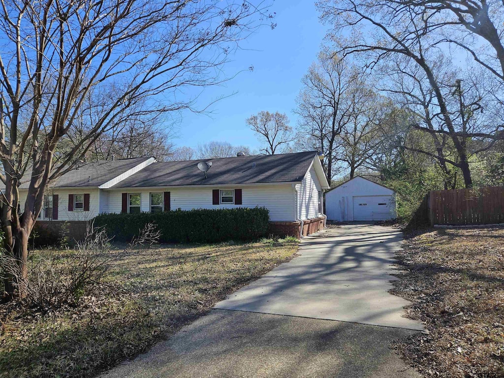 view of front of home featuring a garage, an outbuilding, driveway, and fence