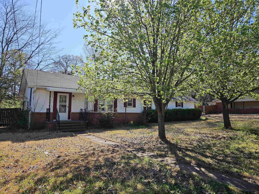 view of front facade featuring brick siding and fence