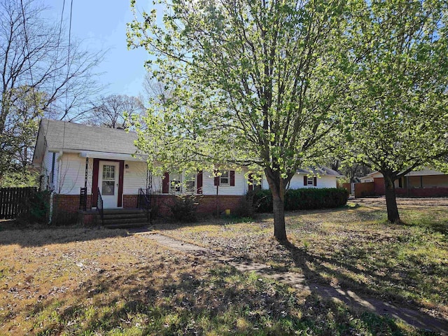 view of front facade featuring brick siding and fence