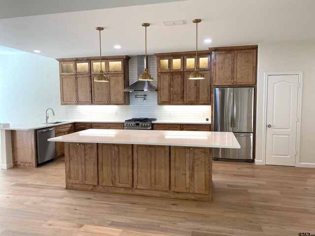 1036 High Meadow Dr, Mount Vernon, TX 75457 - kitchen with appliances with stainless steel finishes, wall chimney range hood, a sink, backsplash, and light wood-style flooring