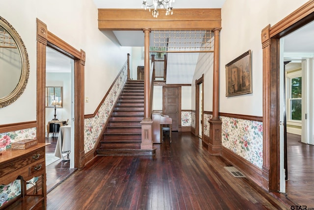 stairs with wood-type flooring and ornate columns