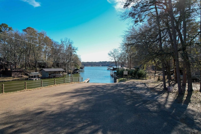 view of water feature featuring a boat dock and fence