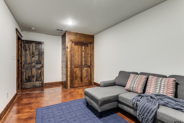 living area with visible vents, baseboards, and finished concrete floors