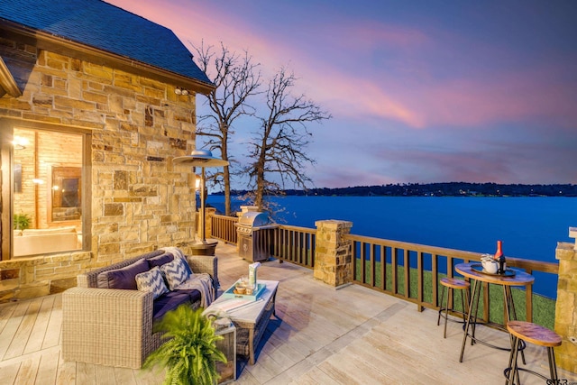 wooden terrace featuring a water view and an outdoor hangout area