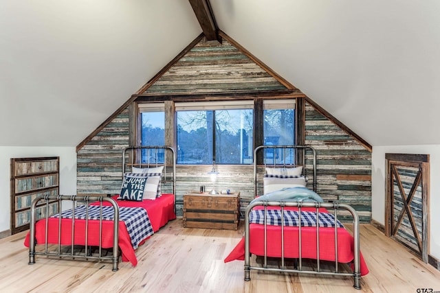 bedroom featuring lofted ceiling with beams and wood finished floors