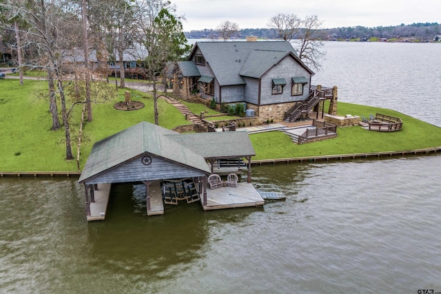 view of dock with a deck with water view, a lawn, and stairs