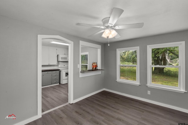 unfurnished dining area with dark hardwood / wood-style flooring and ceiling fan