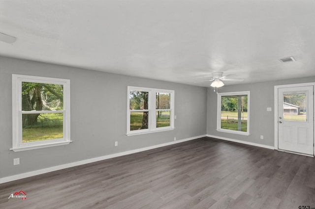 interior space featuring ceiling fan, dark hardwood / wood-style floors, and a healthy amount of sunlight