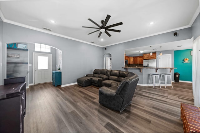 living room with ceiling fan, dark hardwood / wood-style floors, and ornamental molding