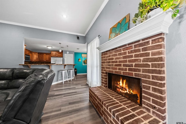 living room featuring crown molding, dark hardwood / wood-style flooring, and a fireplace