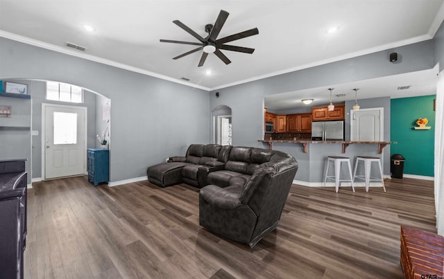 living room featuring dark hardwood / wood-style flooring, ceiling fan, and ornamental molding