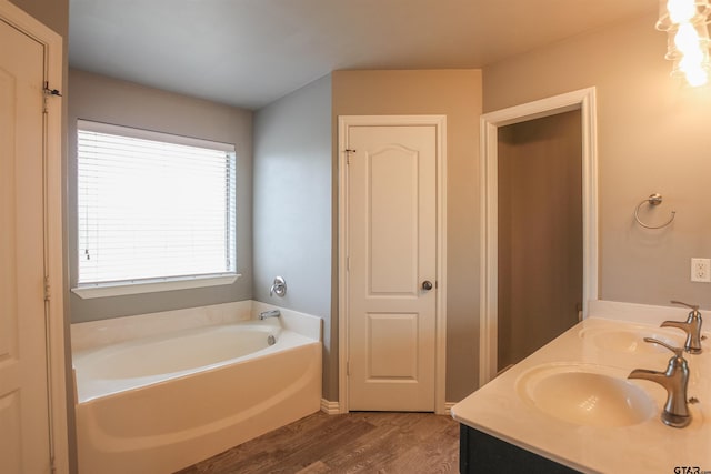 5878 Palo Pinto Dr, Tyler, TX 75707 - bathroom featuring wood finished floors, a garden tub, and double vanity