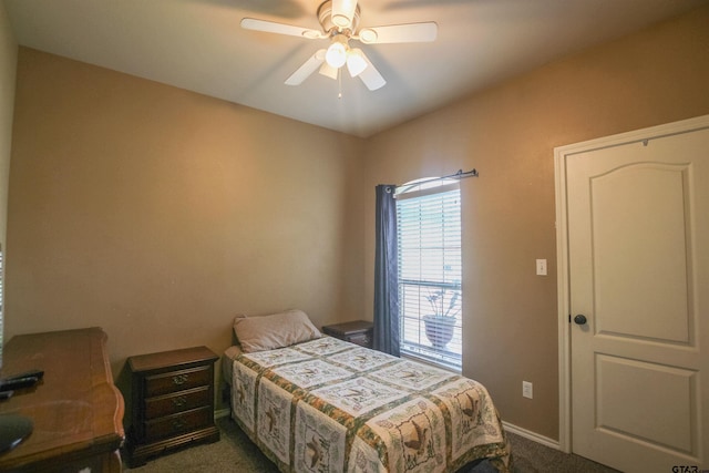 bedroom with a ceiling fan, baseboards, and dark carpet