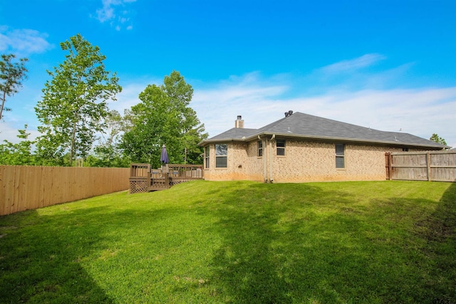 view of yard with a wooden deck and a fenced backyard
