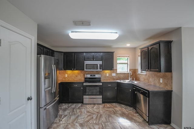 5878 Palo Pinto Dr, Tyler, TX 75707 - kitchen with stainless steel appliances, backsplash, light marble finish floors, and dark cabinetry