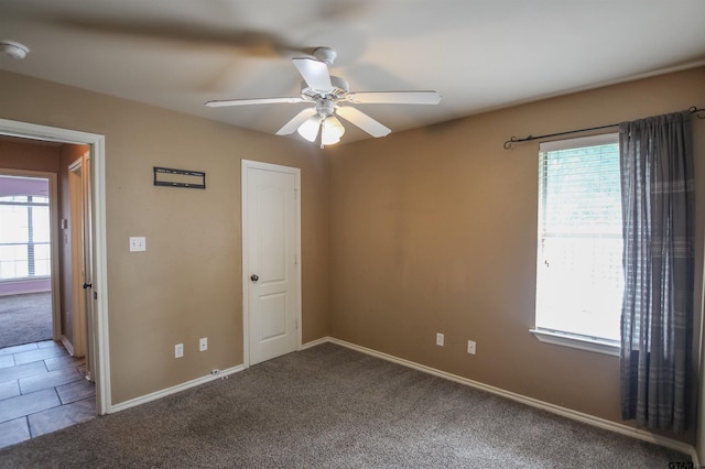 empty room featuring carpet flooring, ceiling fan, and baseboards