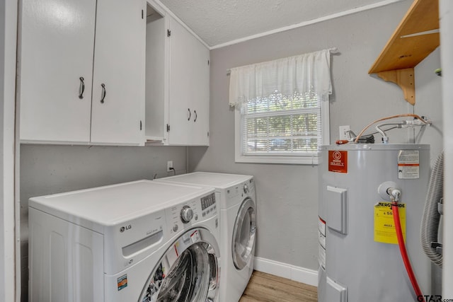 clothes washing area with water heater, cabinets, light hardwood / wood-style floors, a textured ceiling, and washing machine and clothes dryer