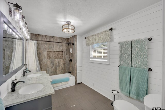 full bathroom featuring shower / bath combo, vanity, a textured ceiling, and toilet