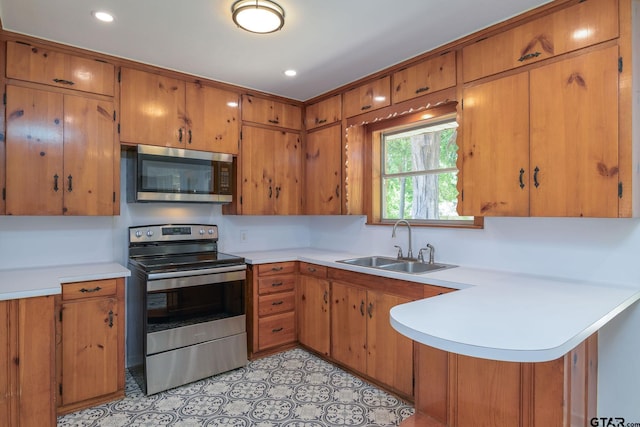 112 Lakeview St, Whitehouse, TX 75791 - kitchen with appliances with stainless steel finishes, brown cabinets, light countertops, a peninsula, and recessed lighting