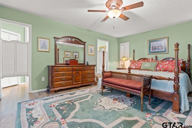 bedroom featuring hardwood / wood-style flooring, ceiling fan, and a textured ceiling