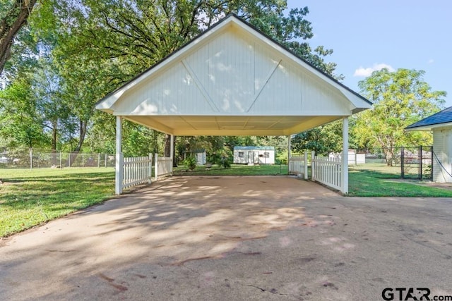 view of parking / parking lot featuring a yard and a carport