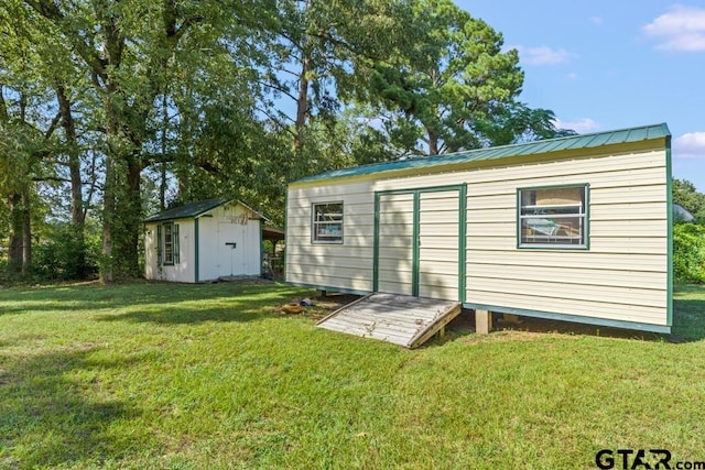 rear view of house with a lawn and a shed