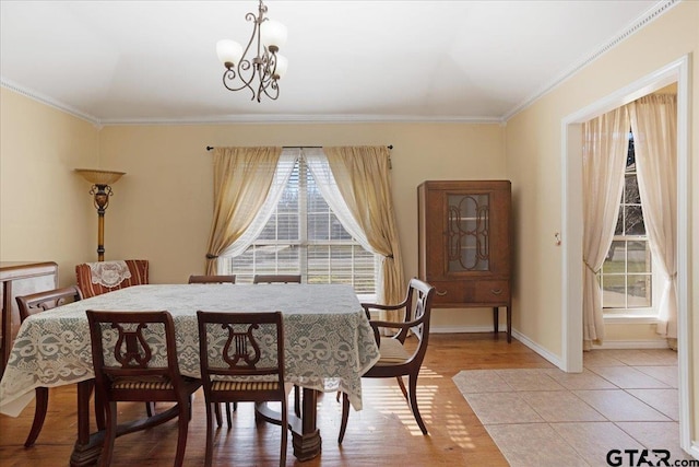 dining space featuring a chandelier, crown molding, a healthy amount of sunlight, and light wood-type flooring