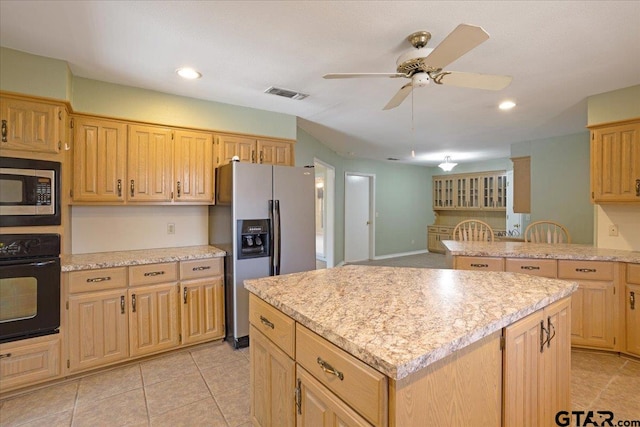 kitchen with appliances with stainless steel finishes, a center island, ceiling fan, and light tile patterned flooring