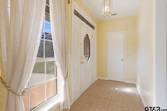 entryway featuring light tile patterned floors, an inviting chandelier, and ornamental molding