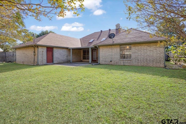 back of property featuring a lawn and a patio area