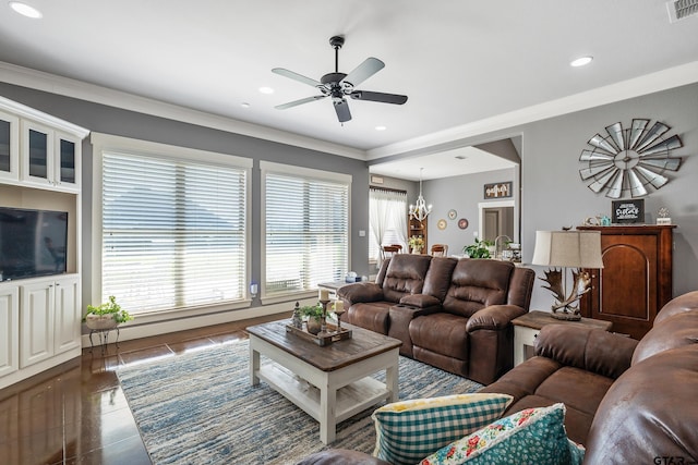 living room with dark tile patterned flooring, crown molding, and ceiling fan with notable chandelier