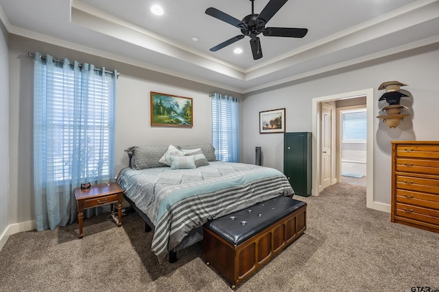 bedroom featuring ceiling fan, ornamental molding, a raised ceiling, and carpet