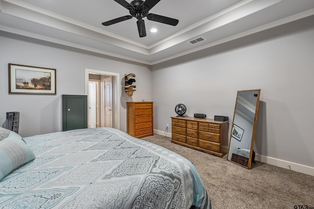 bedroom with crown molding, carpet flooring, ceiling fan, and a tray ceiling