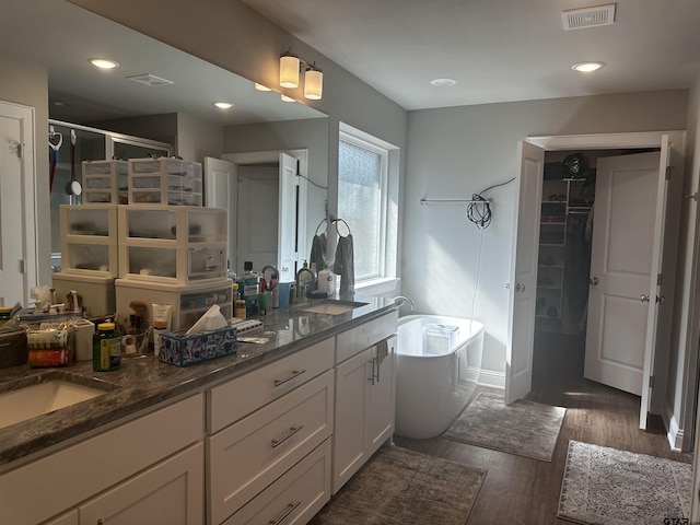 19135 Ambrosia Dr, Flint, TX 75762 - full bath featuring double vanity, a soaking tub, wood finished floors, a shower stall, and recessed lighting