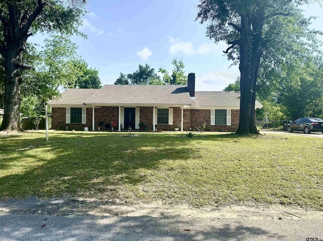 ranch-style house with brick siding, a front lawn, and a chimney