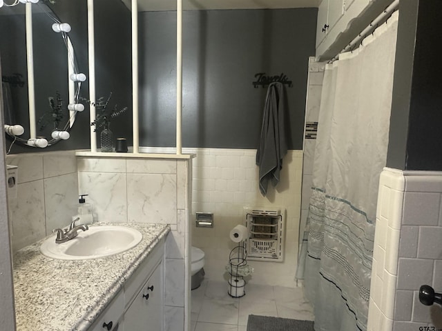 full bathroom with marble finish floor, heating unit, toilet, tile walls, and a wainscoted wall