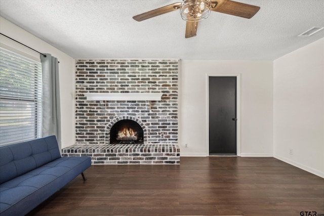 living room with a textured ceiling, a fireplace, wood finished floors, and visible vents